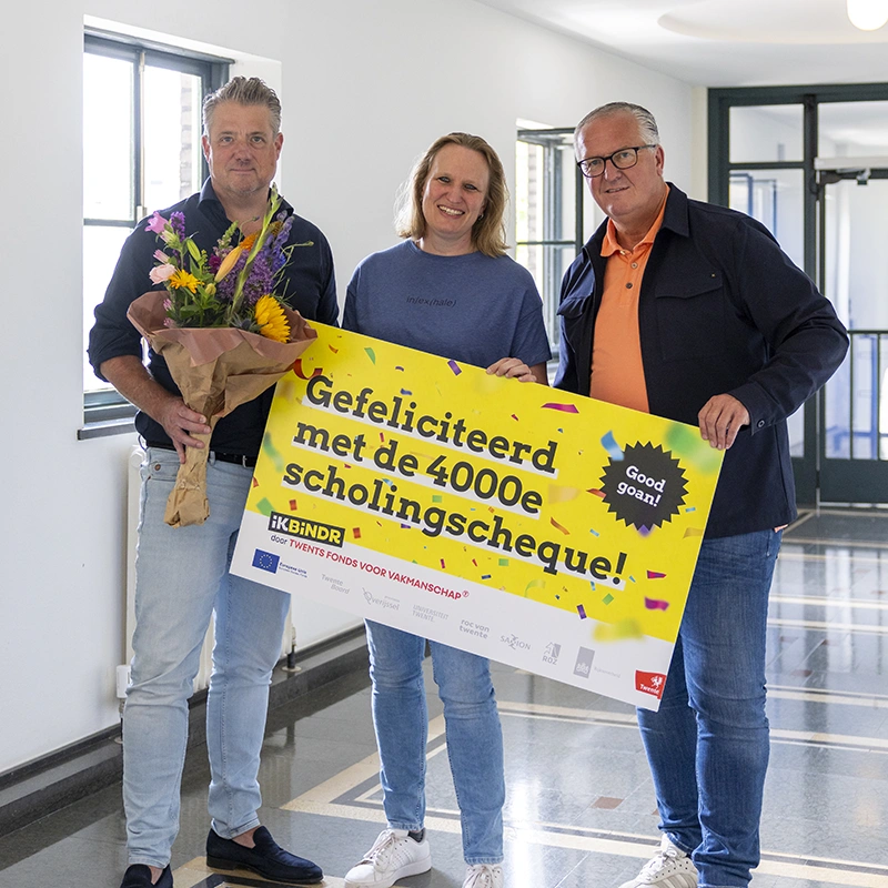 Kandidaat ontvangt de 4000e scholingscheque van ikbindr, met bloemen en feestelijke uitreiking