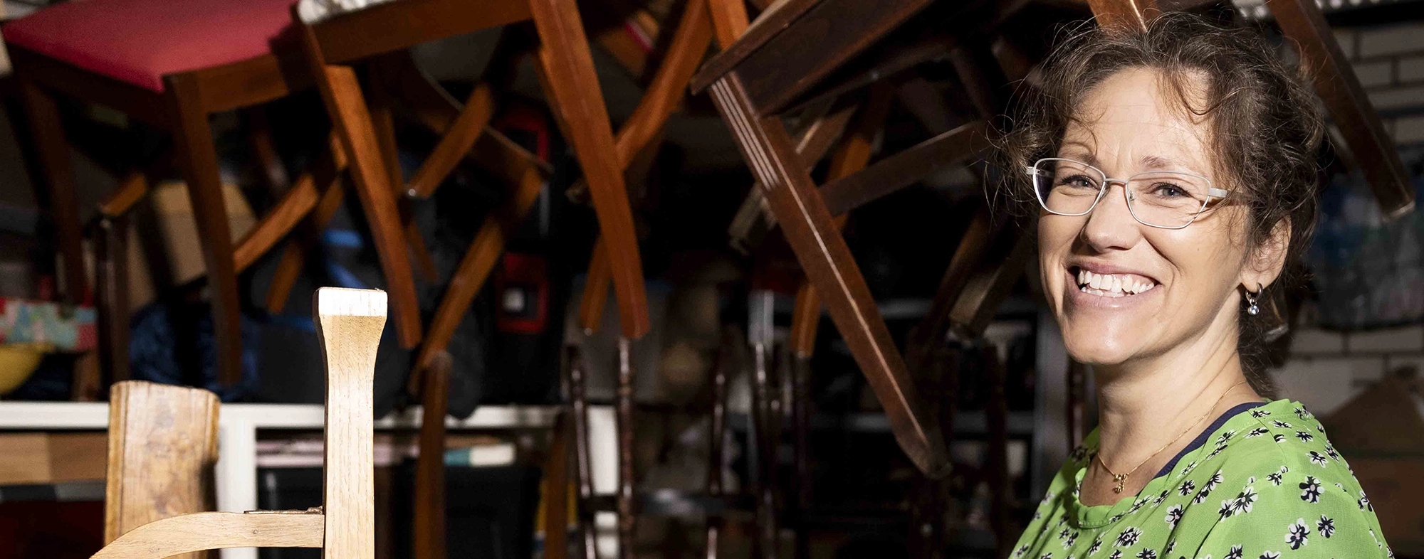 Glimlachende vrouw werkt in een meubelwerkplaats