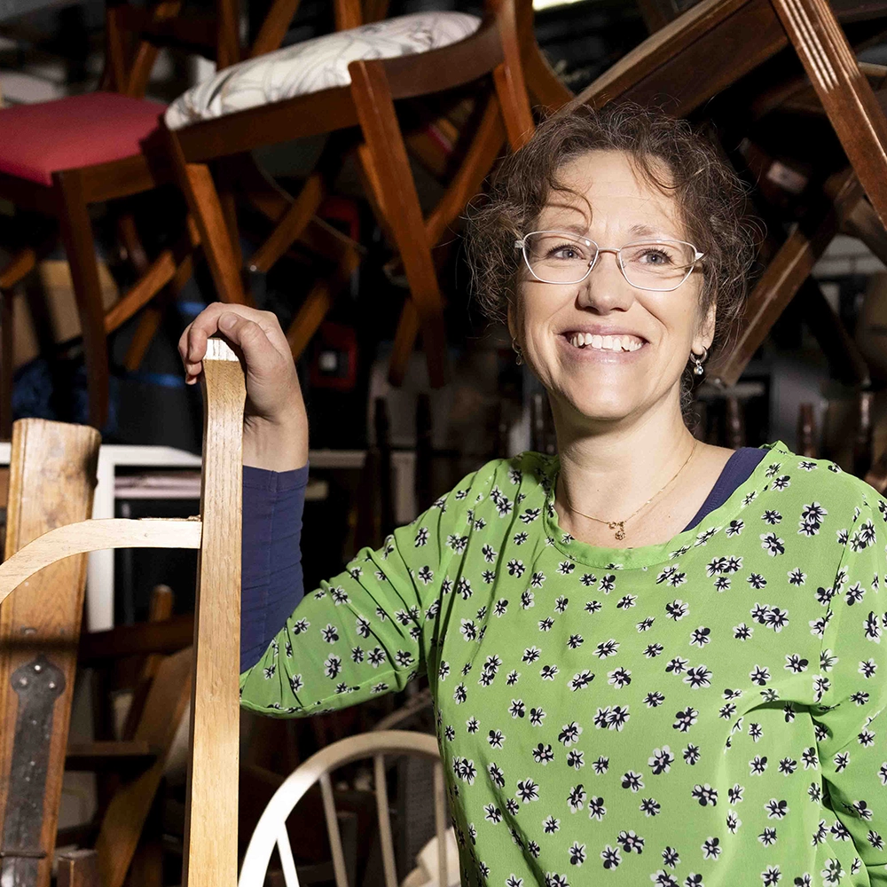 Glimlachende vrouw werkt in een meubelwerkplaats