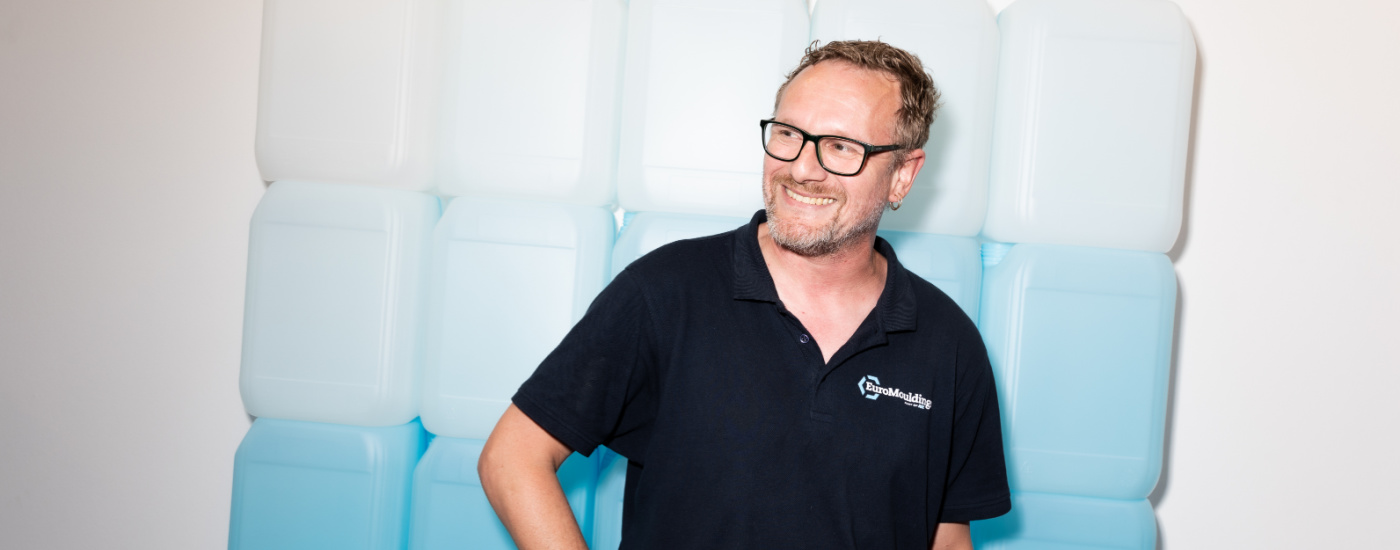 Lachende medewerker in zwart poloshirt tijdens werk bij Euromoldings