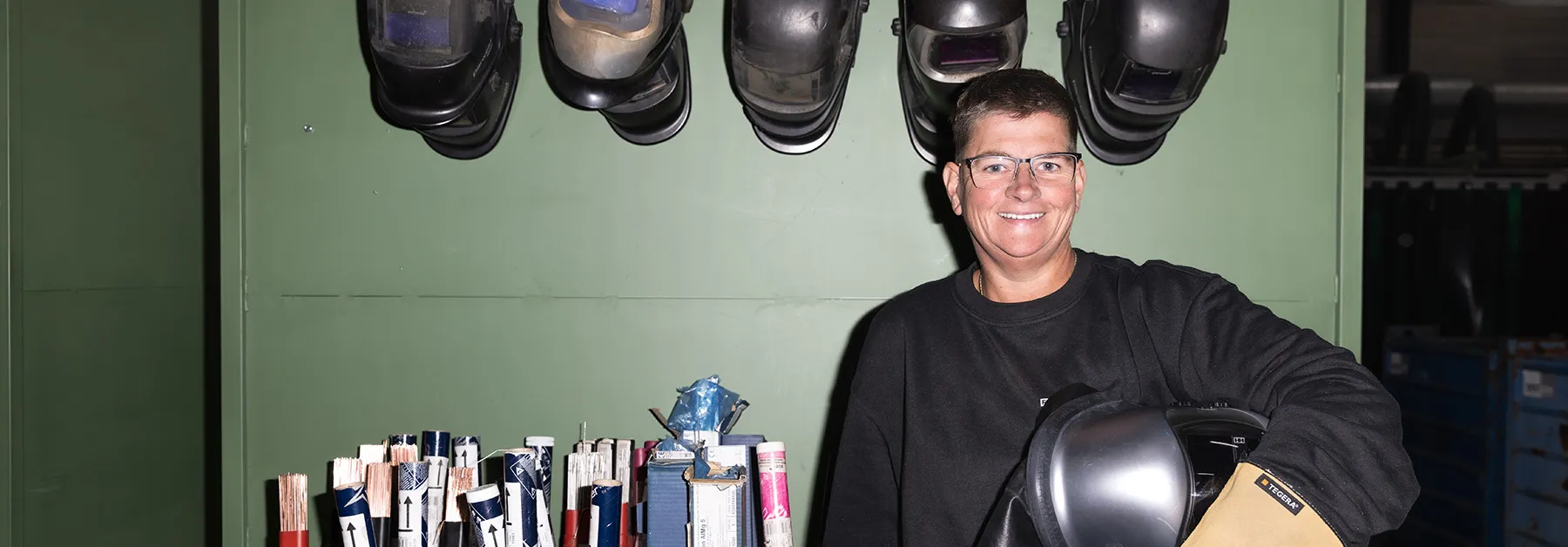 Deelnemer in werkplaats met laskap en beschermende handschoenen, omscholing naar lasser