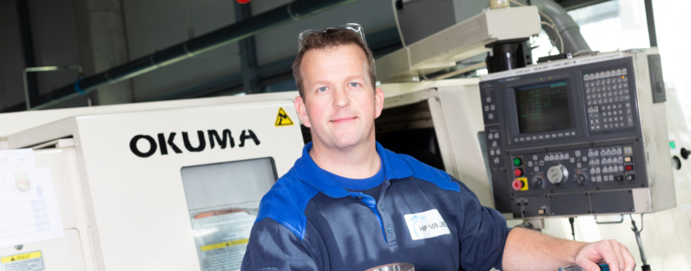 Productiemedewerker naast grote machine in de technieksector