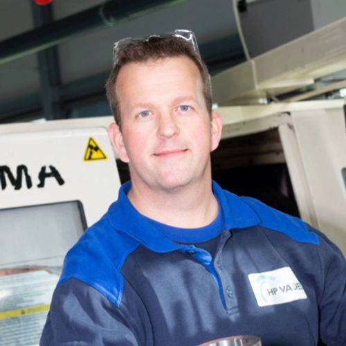 Productiemedewerker naast grote machine in de technieksector