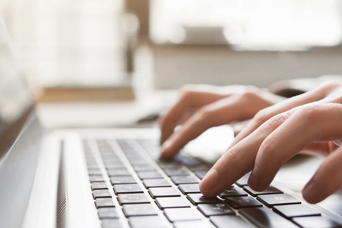 Close-up van handen die typen op een laptop, ICT-opleiding of digitale vaardigheden