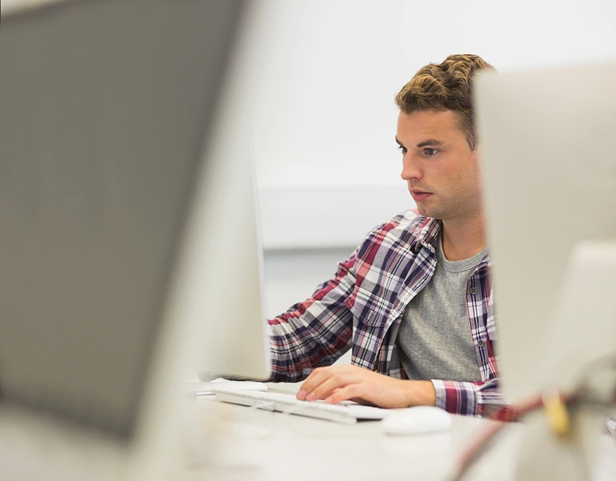 Jonge professional werkt achter een laptop in een moderne kantooromgeving