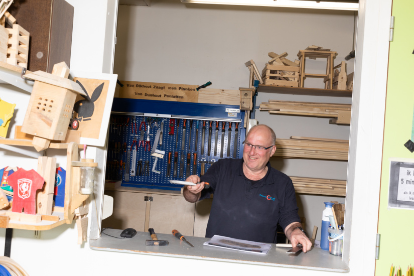 Ervaren medewerker werkt met hout en gereedschap in een werkplaats tijdens omscholingstraject