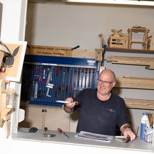 Ervaren medewerker werkt met hout en gereedschap in een werkplaats tijdens omscholingstraject