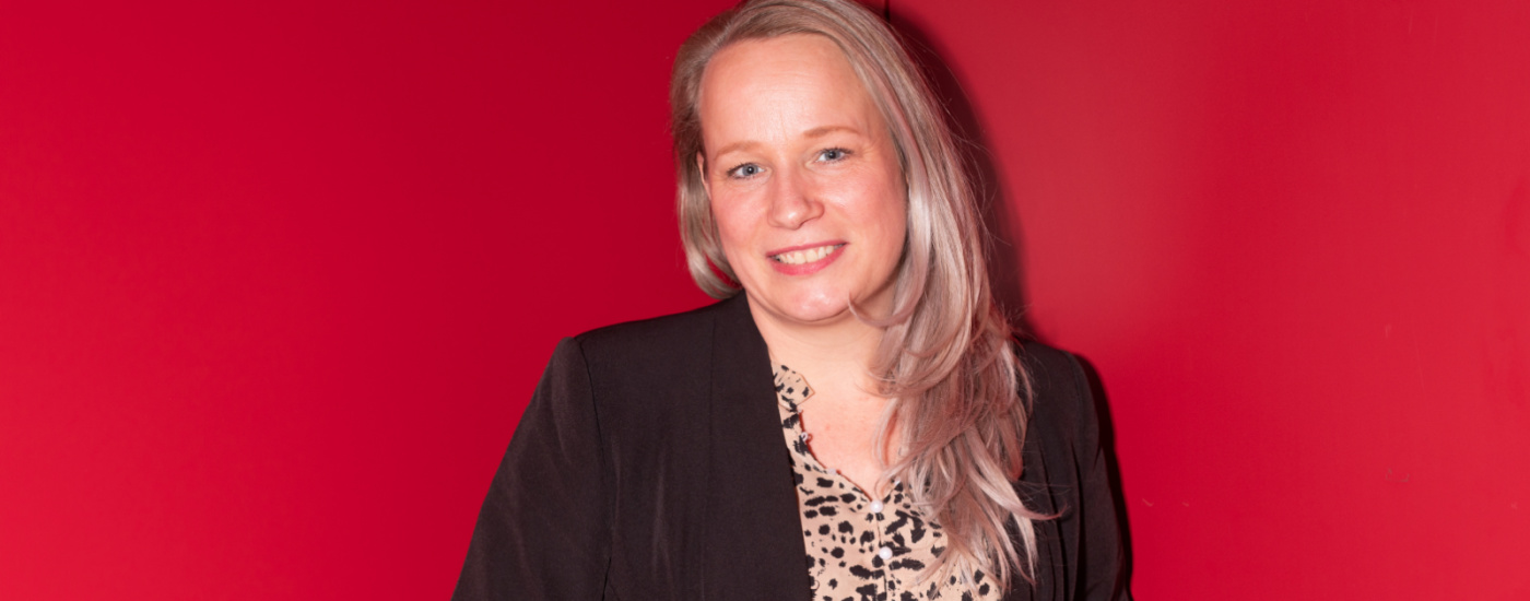 Professionele vrouw poseert voor rode achtergrond