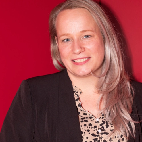 Professionele vrouw poseert voor rode achtergrond