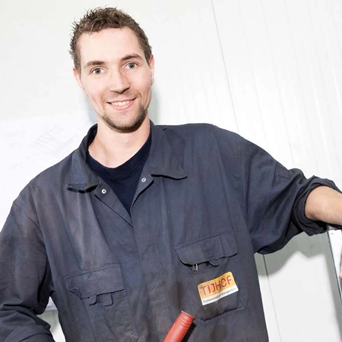 Technisch medewerker in overall werkt aan een industrieel project